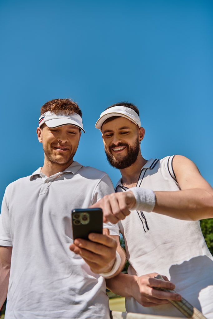 Young gay couple enjoying tennis game on a sunny court in summer day